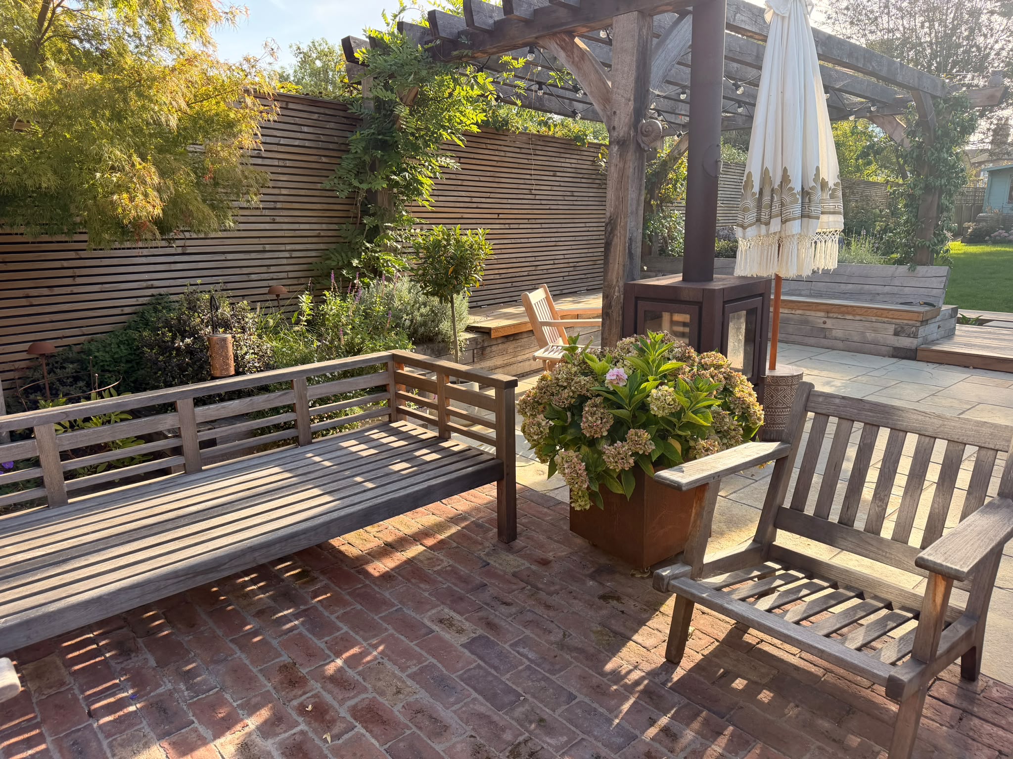 Garden seating beneath a timber pergola in warm September afternoon light